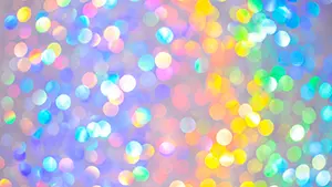 パステルカラーのカラフルな光の丸いボケが無数に重なり合っているキラキラした背景
