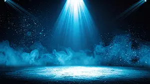 青い強力なスポットライトが地面を照らし周囲に岩の破片や粒子が飛び散っている迫力ある光景