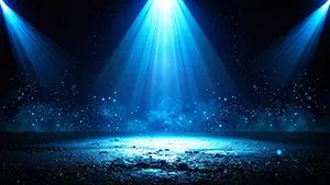 暗闇の中で青いスポットライトが地面を照らし光の粒子が舞っているシンプルで美しい光景