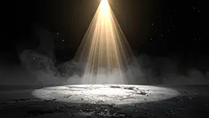 暗闇の中で一本の温かい金色のスポットライトがスモークの漂う床を照らしている風景